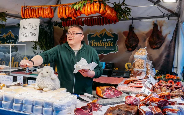 Bir müşteri Caparica, Portekiz için taze yerel peynir örneği pazar satıcı sunar