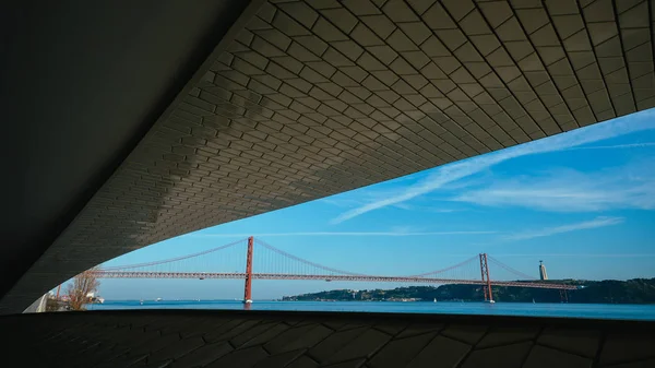 Berühmtes Maat Museum in Lissabon in der Nähe des Flusses tagus eingerahmt mit Lisbon Wahrzeichen 25 der April-Brücke und rei cristo — Stockfoto