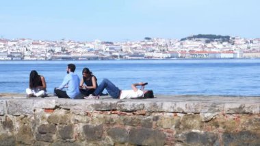 Öbür Tagus Nehri, Portekiz'in Lizbon eski şehir merkezine bakan bir iskelede gençlerin rahatla