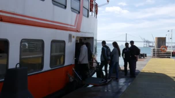 Turiștii care se îmbarcă într-o barcă de feribot la Caes do Sodre cu vedere la podul 25 de aprilie, Portugalia — Videoclip de stoc