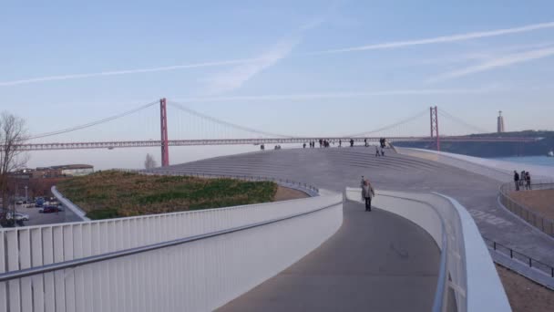 Caducidad de los peatones cerca del río Tajo, Lisboa, Portugal enmarcado por la arquitectura del Museo MAAT — Vídeo de stock