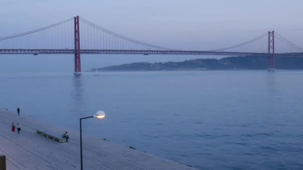 Time-lapse van voetgangers tegenover de iconische 25 April brug in Lissabon, Portugal — Stockvideo