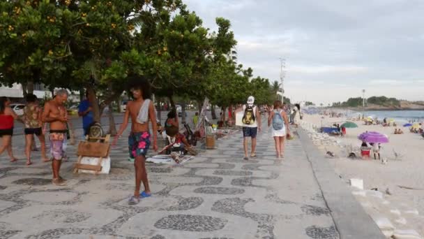 Des piétons marchent à côté de boutiques de souvenirs improvisées installées dans la section Arpoador de la plage d'Ipanema - 4K — Video