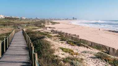 Wooden boardwalk at the Praia da Frente Azul, in english the blue beach front in the seaside resort Espinho clipart