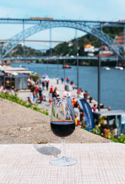 Red wine glass overlooking Cais da Ribeira on the River Douro in Porto, Portugal