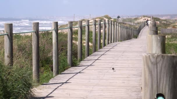 Ludzie spacerują po drewnianej promenady w pobliżu Espinho Beach, Portugalia — Wideo stockowe