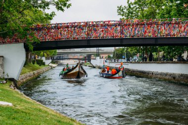 Geleneksel tekne, Moliceiro, Aveiro, Portekiz kanal üzerinde konfeti kaplı köprü altından geçen turistlerin taşıma