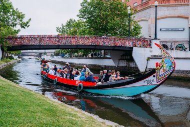 Geleneksel tekne, Moliceiro, Aveiro, Portekiz kanal üzerinde konfeti kaplı köprü altından geçen turistlerin taşıma