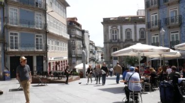 İnsanlar Porto, Portekiz tarihi merkezinde güneşli bir öğleden sonra kafe terasında oturup - 4k