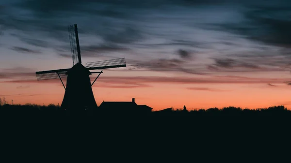 Silhouette del tradizionale mulino a vento olandese al tramonto al tramonto — Foto Stock