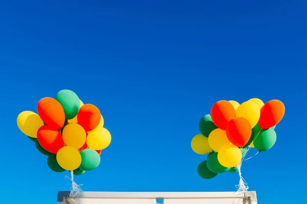 Balões coloridos inundados em um fundo azul céu com reflexão sobre a água — Fotografia de Stock