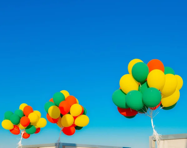 Balões de hélio coloridos contra um céu azul — Fotografia de Stock