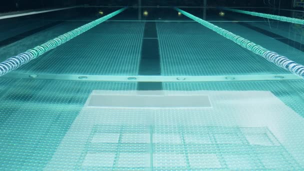 Порожній басейн з невеликими пульсаціями і денним світловим відбиттям від прожектора — стокове відео
