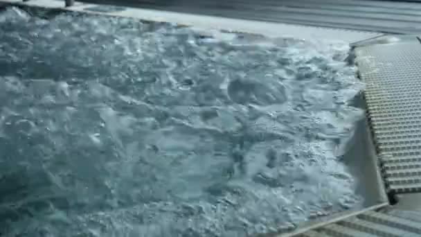 Grandes burbujas en agua tibia en una piscina jacuzzi que muestra la textura del agua hirviendo — Vídeo de stock