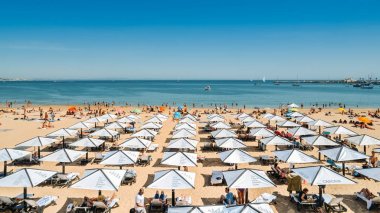 Cascais, Portekiz - 14 Mayıs 2019: Lizbon yakınlarındaki Cascais'te kalabalık kumlu plajın yüksek perspektifi, Portekiz'in Costa Verde bölgesinde. Bu plaj Praia da Conceicao olarak bilinir.