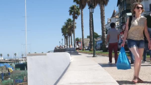 Turistas caminando en el paseo marítimo con vistas a Praia do Ribeiro en Cascais, Portugal — Vídeos de Stock