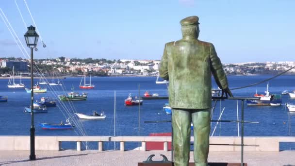 Joven camina junto a la estatua del rey Carlos I con vistas al puerto de Cascais, Portugal — Vídeo de stock