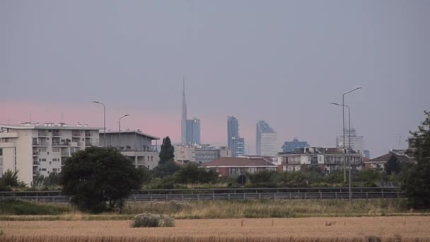 Skyline met moderne wolkenkrabbers uit de buitenwijken met verkeer op de snelweg. Milan, Italië maar zou elke grote stad kunnen zijn — Stockvideo
