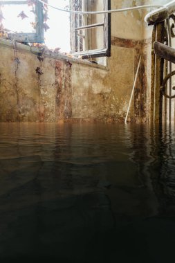 Pencereden gelen güneş ışığı ile sular altında terk edilmiş merdiven