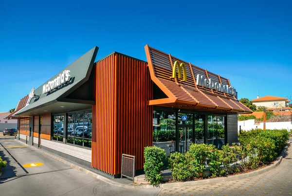 Vista exterior da fachada do moderno restaurante de fast-food McDonalds com drive-thru — Fotografia de Stock