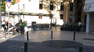 Uber Cascais, Portekiz'de bir Mcdonalds fast-food restoranından yiyecek toplarken bir vespa gıda dağıtım sürücüsü yiyor