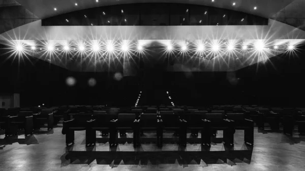 View towards empty audience seats at from stage with deliberate spotlights - monochrome — Stock Photo, Image