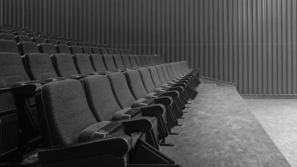 Selective perspective view towards empty audience seat in an indoor performance hall or cinema