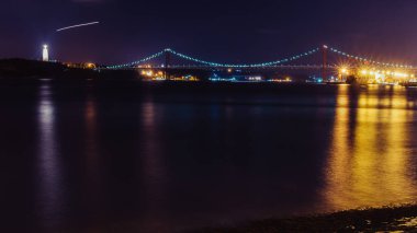 Lizbon'daki 25 Nisan Köprüsü Panoraması, Portekiz Tagus Nehri'ni geçiyor. Solda Cristo Rei Heykeli, Portekiz