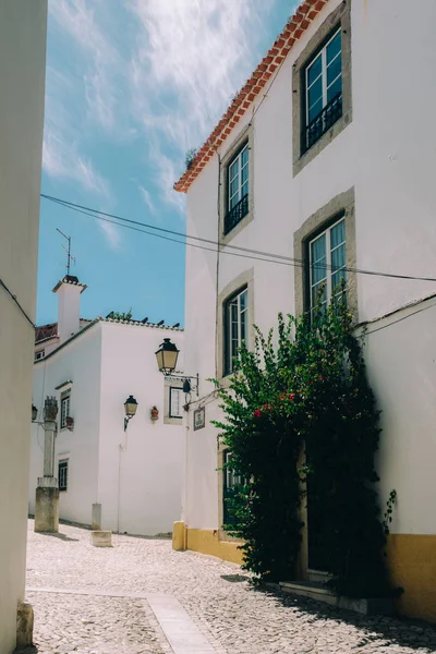 Charmoso beco estreito de paralelepípedos entre casas caiadas de branco e paredes na cidade velha de Cascais, Portugal — Fotografia de Stock