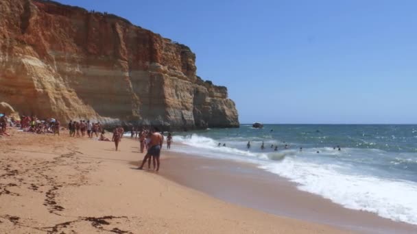 Benagil plajında altın renkli kayalıklar, işlek plaj ve turkuaz okyanusun yüksek perspektif görünümü, Lagoa, Algarve, Portekiz — Stok video