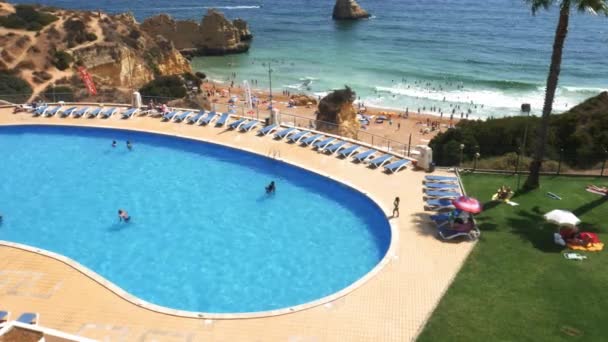 Algarve Cova Redonda Plajı'nda yüzme havuzu ve plajda insanların yüksek perspektif tilt, Portekiz — Stok video