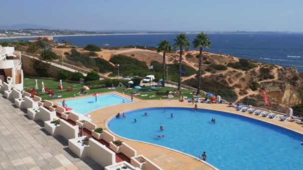 Hochperspektivische Ansicht von Menschen am Pool und Strand am Strand von Cova Redonda an der Algarve, Portugal — Stockvideo