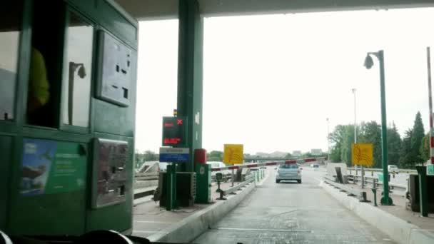 Passenger POV of female driver paying and receiving a receipt at a toll booth on a Portuguese highway — Stock Video