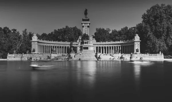 Monochrome lange blootstelling van mensen op boten tegenover monument aan Alfonso Xii in het Parque del Buen Retiro, bekend als het Park van de Pleasant Retreat in Madrid, Spanje — Stockfoto