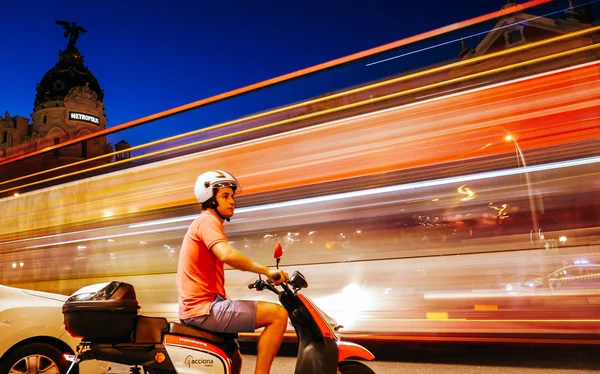 Ung man på en vespa väntar på att trafiken ska passera vid den livliga farliga korsningen Calle de Alcala och Gran Via i Madrid, Spanien — Stockfoto