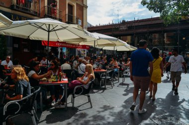 Madrid, İspanya 'daki San Miguel Market' in dışındaki terasta oturan insanlar.
