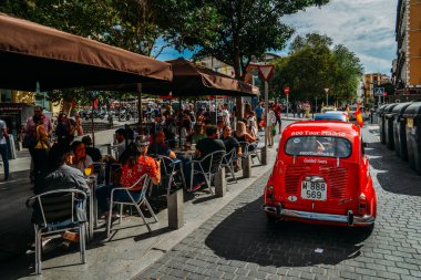 İnsanlar yaz boyunca Madrid 'in tarihi merkezinde bir terasta içki içip sohbet etmekten keyif alıyorlar.