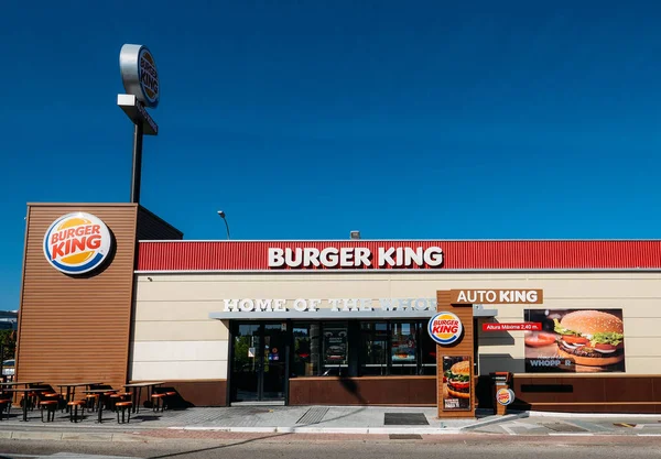 Fuera de un restaurante de comida rápida Burger King con un aspecto elegante y contemporáneo futurista industrial incluye revestimiento de ladrillo y punto de orden drive-thru — Foto de Stock