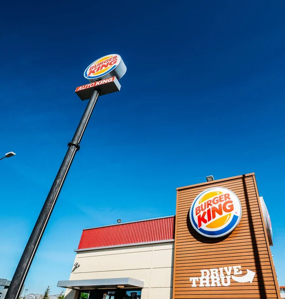 Fuera de un restaurante de comida rápida Burger King con un aspecto elegante y contemporáneo futurista industrial incluye revestimiento de ladrillo y punto de orden drive-thru — Foto de Stock