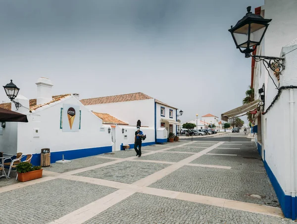 Piazza principale con le persone che si rilassano nei caffè nella pittoresca Porto Covo in Portogallo — Foto Stock