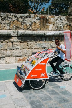 Genç adam Cascais, Portekiz 'de sokaklarda gazete satıyor.