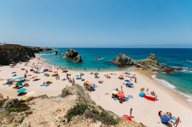 Alentejo, Portugal - July 19, 2020: Beachgoers at Praia Samoqueira, Porto Covo - Portugal clipart
