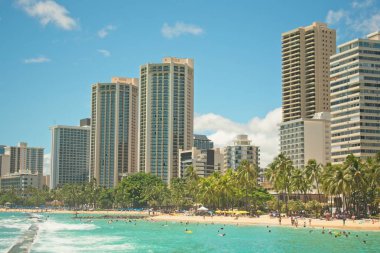 Waikiki Beach ve Kuhio Beach Park güneşli bir günde turistler tarafından popüler.