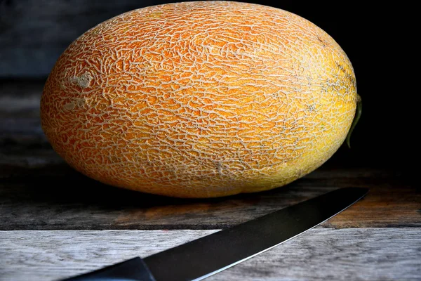 Fruto Entero Melón Con Cuchillo Sobre Una Vieja Mesa Rústica — Foto de Stock