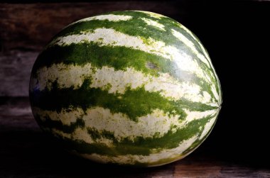 Bütün, yeşil, çizgili, karpuz, eski bir rustik masada.