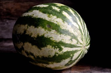 Bütün, yeşil, çizgili, karpuz, eski bir rustik masada.