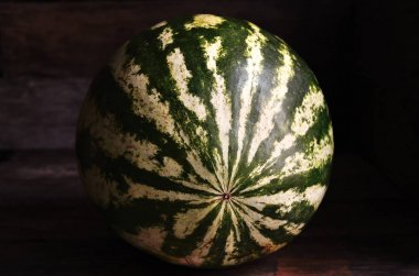 Bütün, yeşil, çizgili, karpuz, eski bir rustik masada.