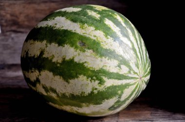 Bütün, yeşil, çizgili, karpuz, eski bir rustik masada.