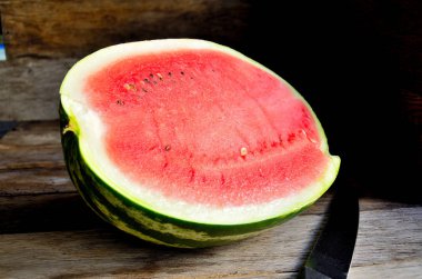 Eski bir rustik masada ikiye kesilmiş bir karpuz.