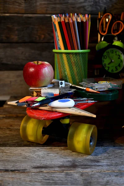 School supplies located on a skateboard.